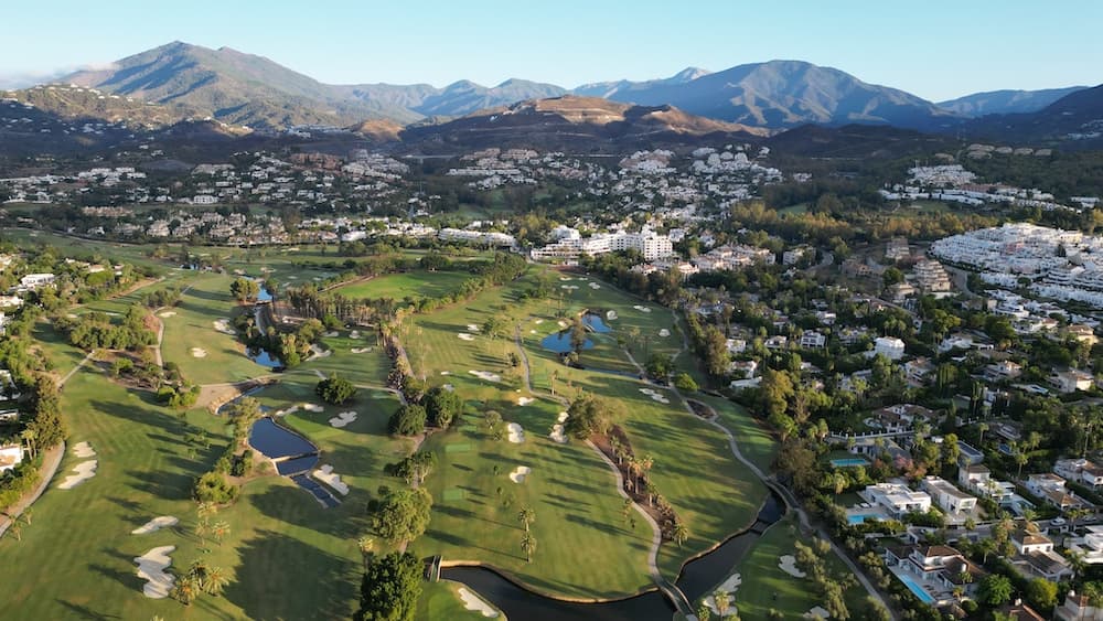 Aerial view of Nueva Andalucía Golf Valley in Marbella, surrounded by residential areas and mountains